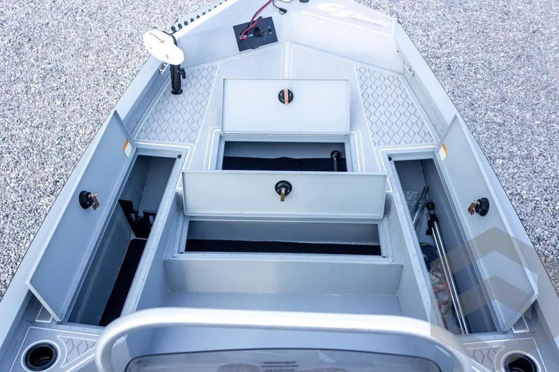 Slide: The Image of 2026 G3 Bay 21 GX boat interior with open storage compartments on gravel surface. - 27