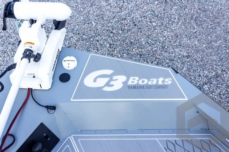 Slide: The Image of 2026 G3 Bay 21 GX boat deck with Minn Kota motor, gravel background. - 34