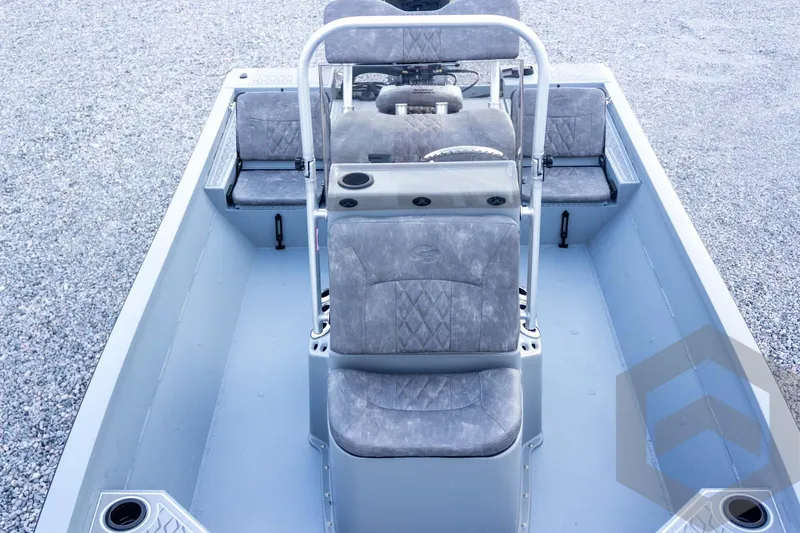 Slide: The Image of 2026 G3 Bay 21 GX boat interior with gray seating and console, on gravel surface. - 35