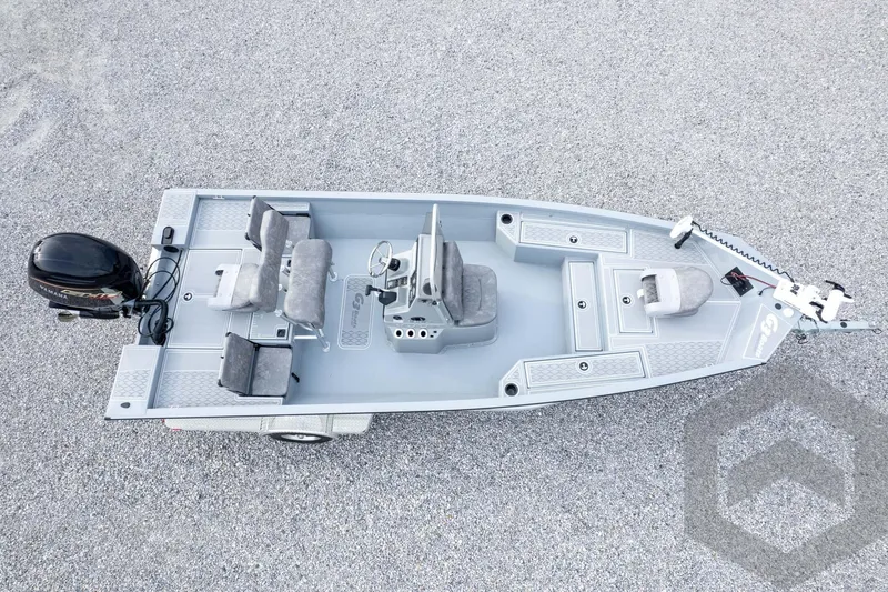 Slide: The Image of 2026 G3 Bay 21 GX boat, aerial view, featuring seating and motor on gravel surface. - 63
