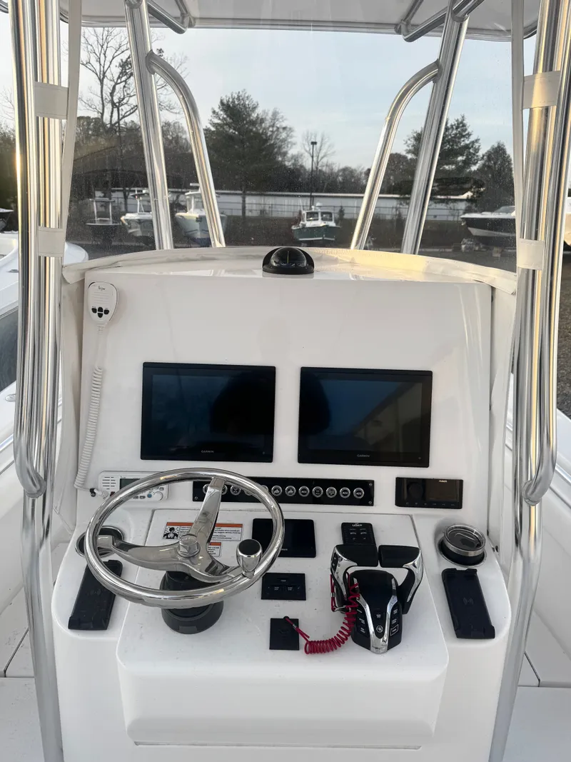 Slide: The Image of 2024 Contender 25 Tournament CC boat console with dual screens and steering wheel. - 10