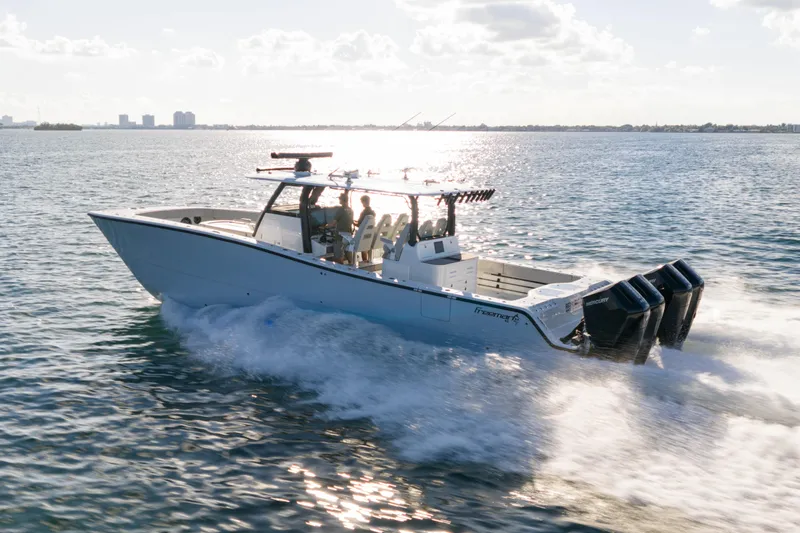 Slide: The Image of 2022 Freeman 43 boat cruising on open water with multiple outboard engines. - 2