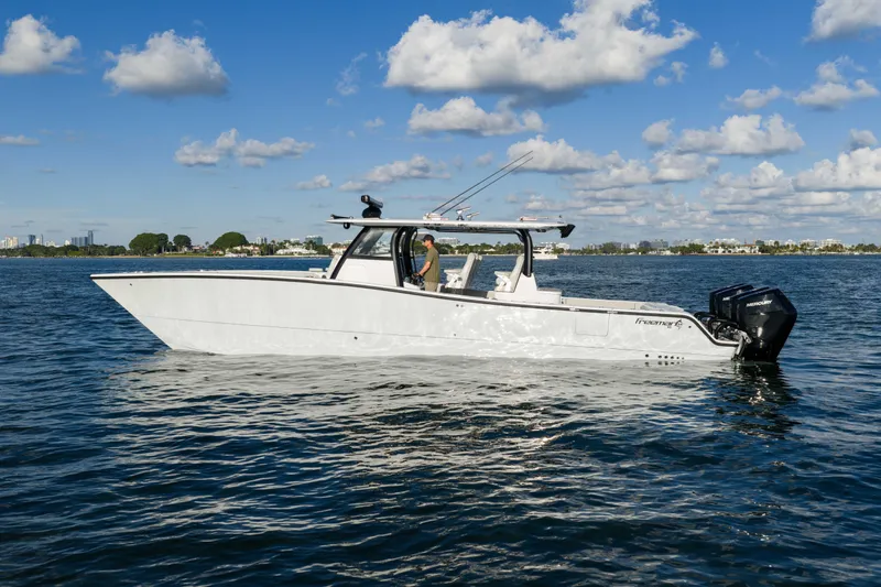 Slide: The Image of 2022 Freeman 43 boat on calm water under a blue sky with clouds. - 8