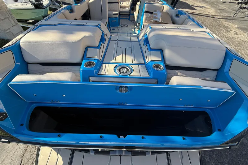 Slide: The Image of 2026 Supra SL 550 boat interior with blue and white seating, cup holders, and storage compartments. - 13