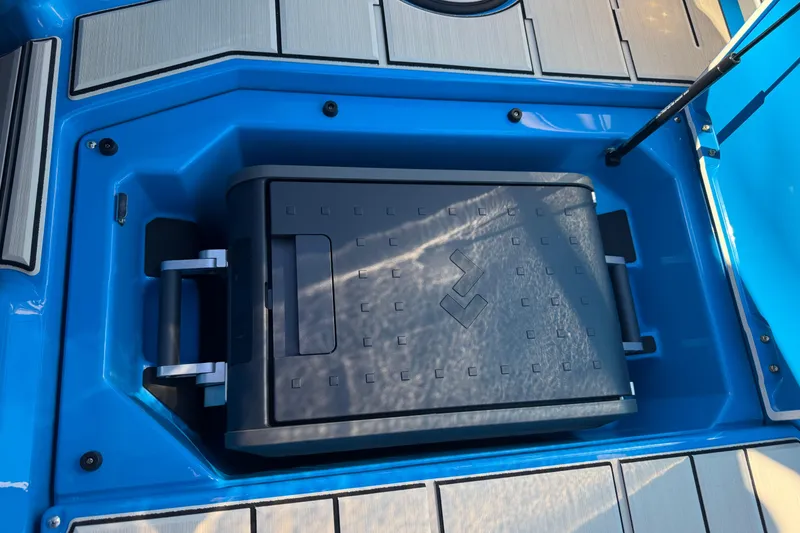 Slide: The Image of 2026 Supra SL 550 boat storage compartment with a black cooler inside. - 34