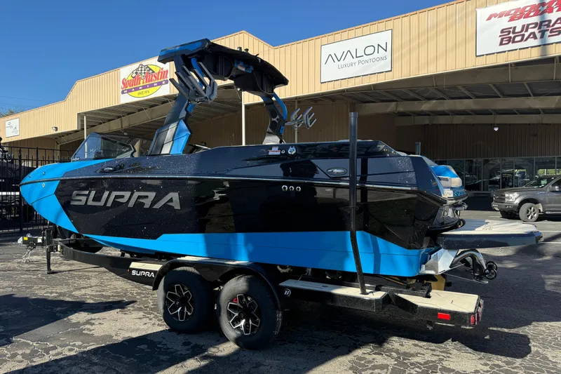 Slide: The Image of 2026 Supra SL 550 boat in black and blue, parked outside a dealership. - 59