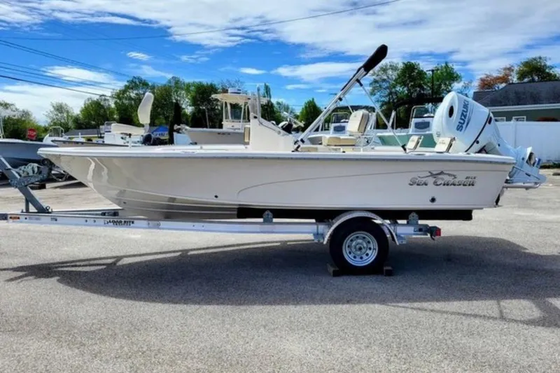 The Image of 2022 Sea Chaser 21 LX boat on trailer, parked outdoors under blue sky. - 1