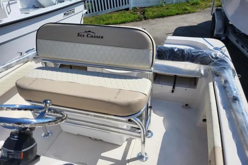 Slide: The Image of 2022 Sea Chaser 21 LX boat interior with cushioned seating and steering wheel. - 10