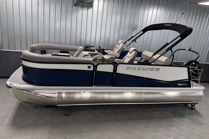 The Image of 2026 Premier 210 Sunsation RL Tritoon boat in showroom, featuring sleek design and comfortable seating. - 0