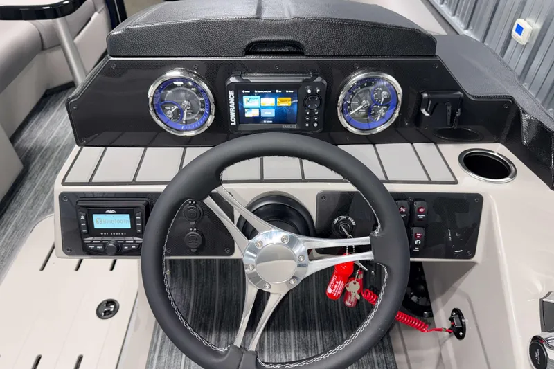 Slide: The Image of 2026 Premier 210 Sunsation RL Tritoon dashboard with steering wheel and modern controls. - 11