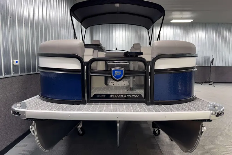 Slide: The Image of 2026 Premier 210 Sunsation RL Tritoon in a showroom, showcasing sleek design and luxury features. - 2