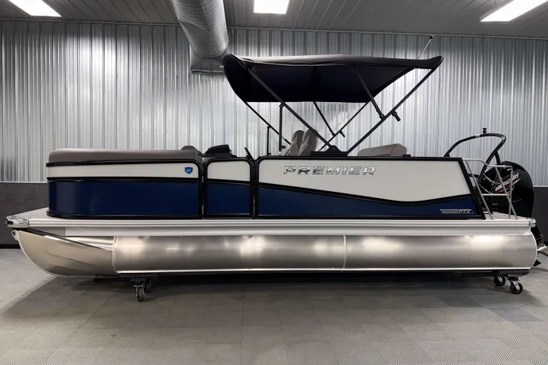 Slide: The Image of 2026 Premier 210 Sunsation RL Tritoon in showroom, featuring sleek design and canopy. - 3