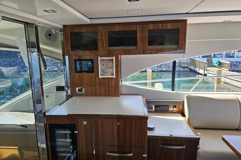Slide: The Image of Interior of 2023 Riviera 5400 Sport Yacht with elegant wood cabinetry and modern design. - 2
