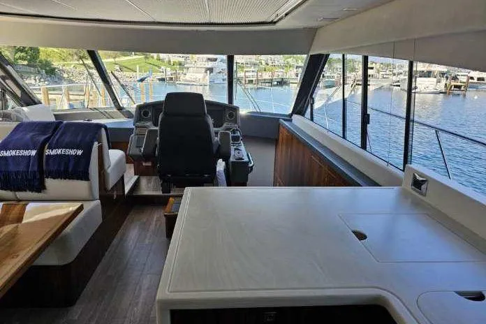 Slide: The Image of Interior of 2023 Riviera 5400 Sport Yacht with helm and marina view. - 4