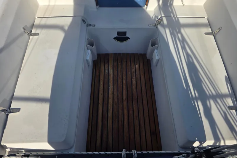 Slide: The Image of 1985 Express Yachting Express 30 cockpit with wooden floor and white seating. - 16