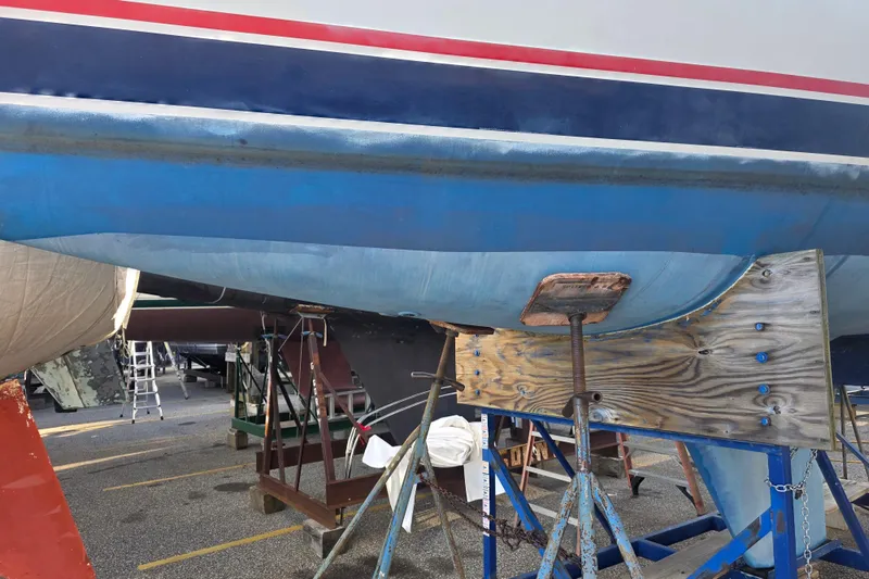 Slide: The Image of 1985 Express Yachting Express 30 sailboat on stands, undergoing maintenance in a boatyard. - 31