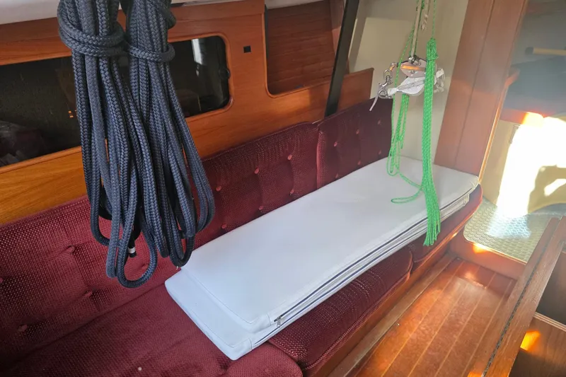 Slide: The Image of Interior of 1985 Express Yachting Express 30 with maroon seating and nautical ropes. - 36