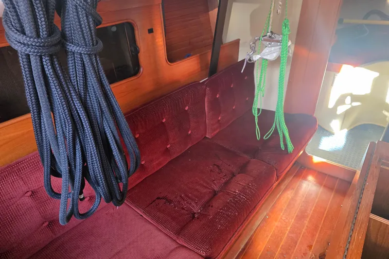 Slide: The Image of Interior of 1985 Express Yachting Express 30 with maroon seating and nautical ropes. - 37