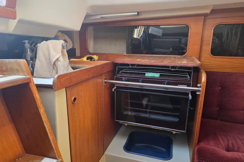 Slide: The Image of Interior of 1985 Express Yachting Express 30, featuring a compact kitchen area. - 4