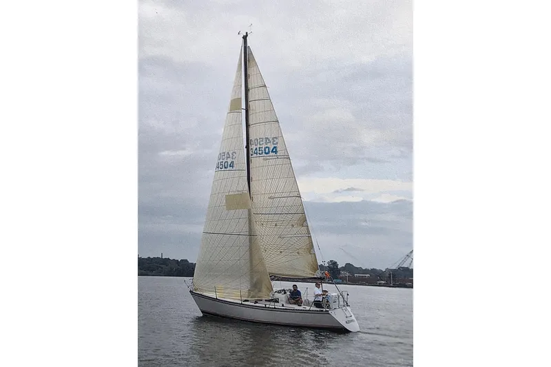 Slide: The Image of 1985 Express Yachting Express 30 sailboat on calm water under cloudy sky. - 53