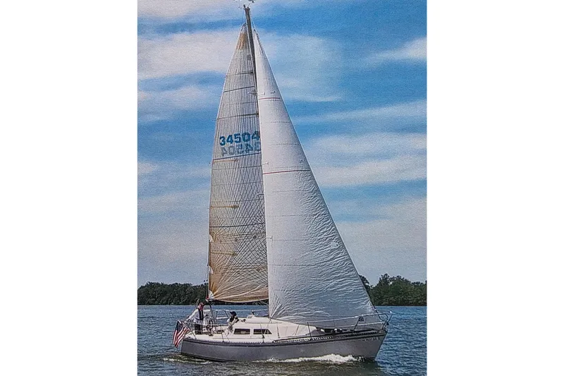 Slide: The Image of 1985 Express Yachting Express 30 sailboat on open water under clear skies. - 54