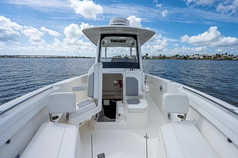 Slide: The Image of 2021 Pursuit S 288 Sport boat interior with seating, on a sunny day at sea. - 10