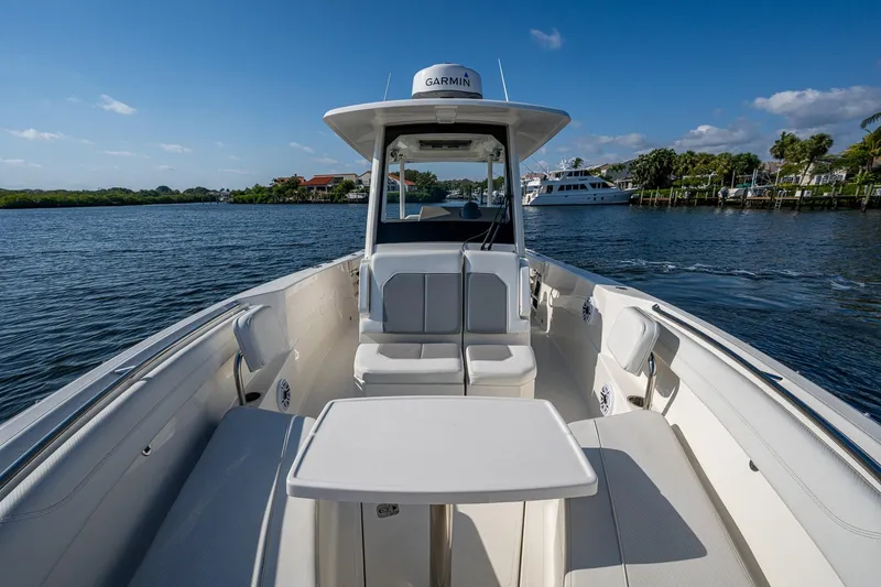 Slide: The Image of 2021 Pursuit S 288 Sport boat interior with seating and table on a sunny day. - 12