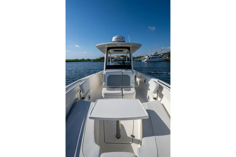 Slide: The Image of 2021 Pursuit S 288 Sport boat interior with seating and table on calm water. - 13