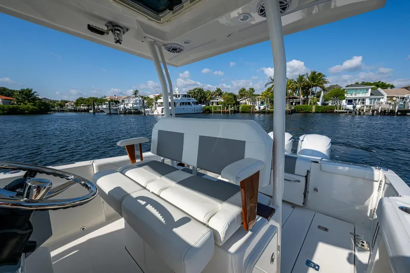 Slide: The Image of 2021 Pursuit S 288 Sport boat interior with luxurious seating, overlooking a scenic waterfront. - 16