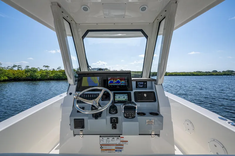 Slide: The Image of 2021 Pursuit S 288 Sport boat helm with advanced navigation system on calm water. - 18