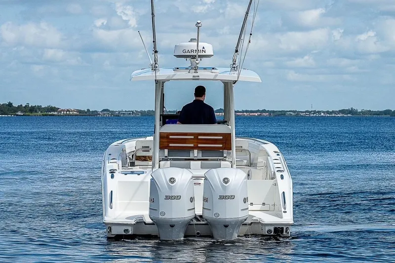 Slide: The Image of 2021 Pursuit S 288 Sport boat on calm water, rear view with dual engines. - 2