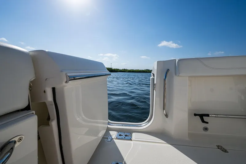 Slide: The Image of 2021 Pursuit S 288 Sport boat interior with open door, overlooking calm water and blue sky. - 24