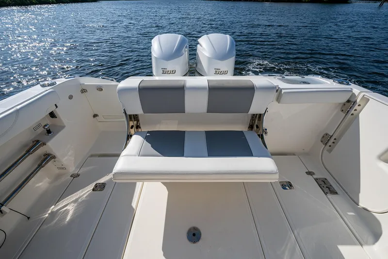 Slide: The Image of 2021 Pursuit S 288 Sport boat with dual engines and cushioned seating on the water. - 26