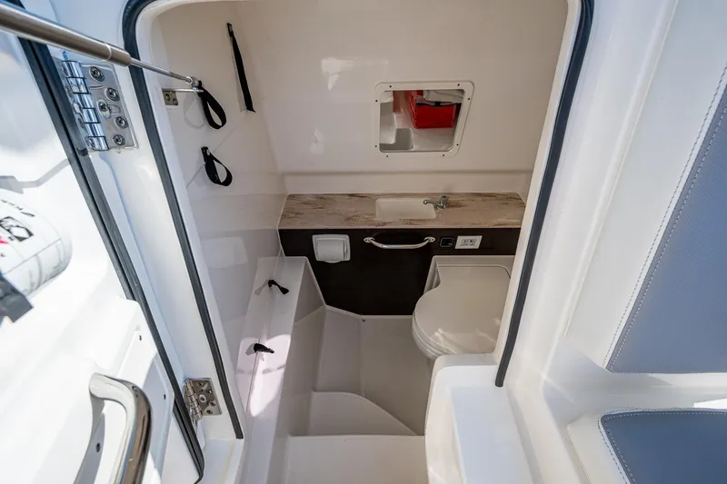 Slide: The Image of 2021 Pursuit S 288 Sport boat interior with compact bathroom and sink. - 30