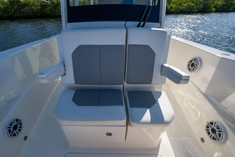 Slide: The Image of 2021 Pursuit S 288 Sport boat seating with armrests and speakers, on a sunny day. - 31