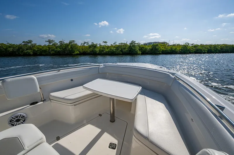 Slide: The Image of 2021 Pursuit S 288 Sport boat interior with seating and table on a sunny day. - 8