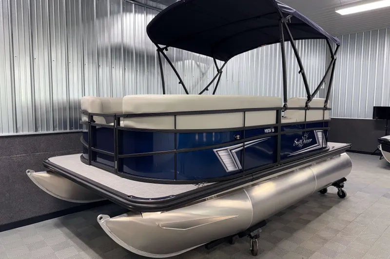 Slide: The Image of 2026 SunChaser Vista 16 LR pontoon boat in showroom, featuring sleek design and comfortable seating. - 15