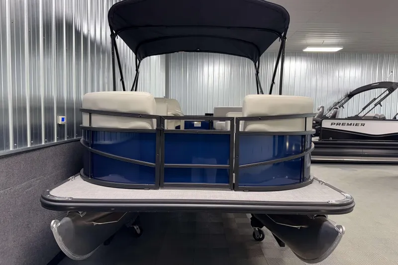 Slide: The Image of 2026 SunChaser Vista 16 LR pontoon boat in showroom, featuring blue exterior and canopy. - 16