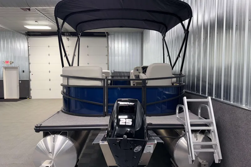 Slide: The Image of 2026 SunChaser Vista 16 LR pontoon boat in a metal-walled garage. - 19