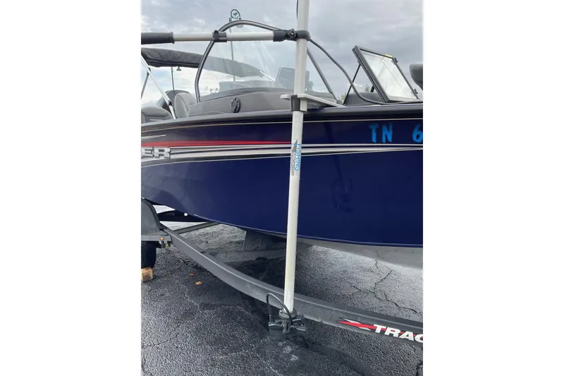 Slide: The Image of 2024 Tracker Targa V-19 Combo boat on trailer, blue hull, parked outdoors. - 14