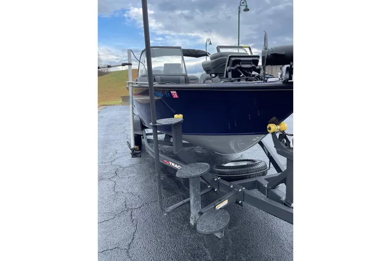 Slide: The Image of 2024 Tracker Targa V-19 Combo boat on trailer, parked on wet pavement. - 15