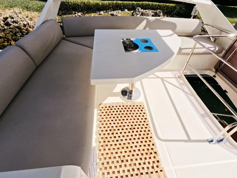 Slide: The Image of Prestige 460 yacht 2020 model, featuring a sleek outdoor seating area with table. - 14