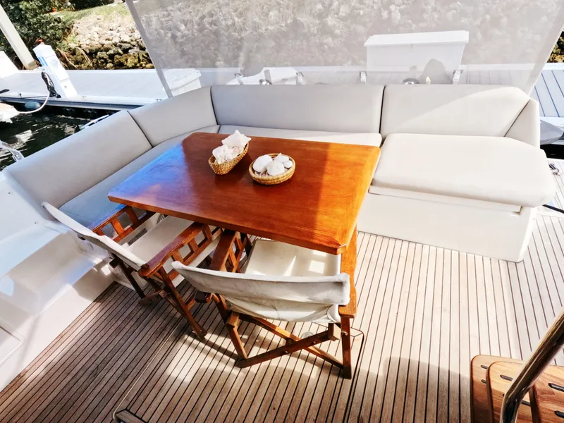 Slide: The Image of Luxury seating area on 2020 Prestige 460 yacht with wooden table and cushioned benches. - 17
