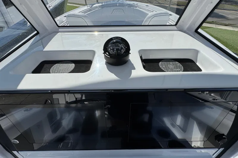Slide: The Image of 2026 Sportsman Open 262 Center Console boat dashboard with compass and storage compartments. - 12