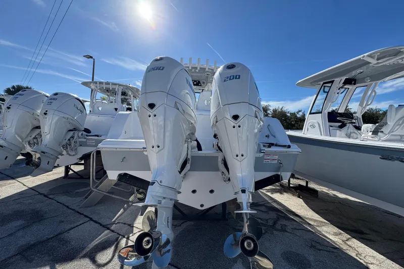 Slide: The Image of 2026 Sportsman Open 262 Center Console with twin outboard engines under sunny sky. - 3