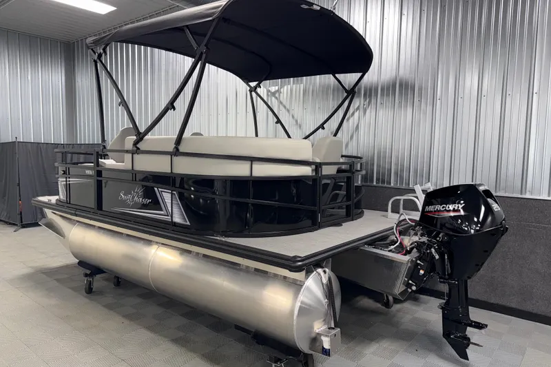 Slide: The Image of 2026 SunChaser Vista 16 Fish pontoon boat with canopy and Mercury outboard motor in showroom. - 21