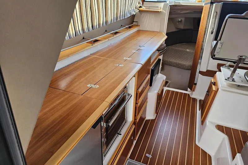 Slide: The Image of 2022 Cuwater C-32-CB boat interior with wood finish and modern amenities. - 13