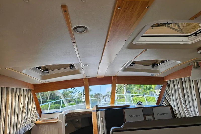 Slide: The Image of Interior view of 2022 Cuwater C-32-CB boat with striped curtains and Garmin equipment. - 15