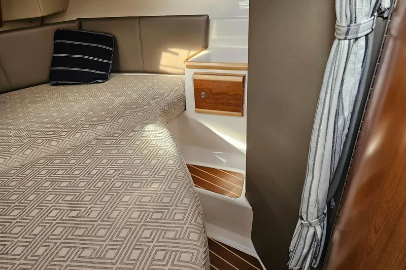 Slide: The Image of Cozy cabin interior of 2022 Cuwater C-32-CB with patterned bedding and wooden accents. - 19