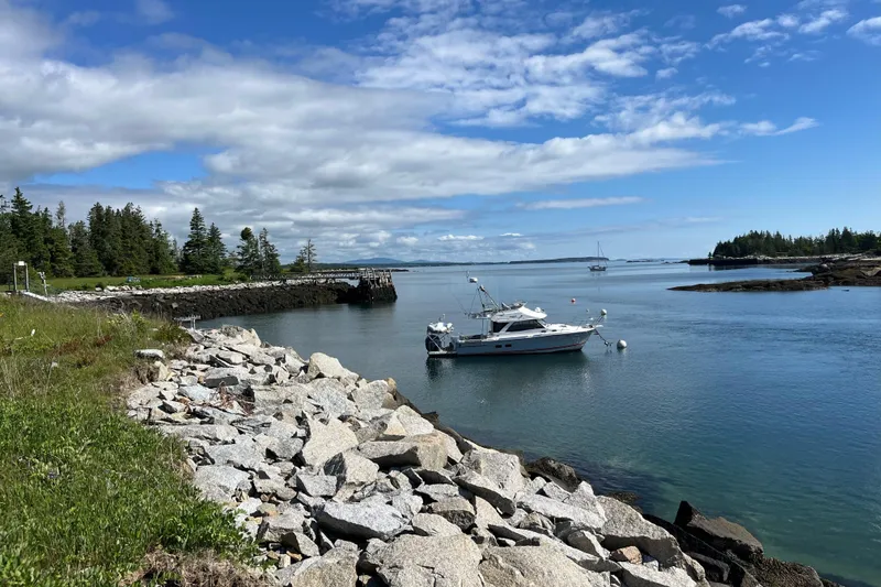 Slide: The Image of Boat "Cuwater C-32-CB" 2022 model anchored in scenic coastal bay. - 2